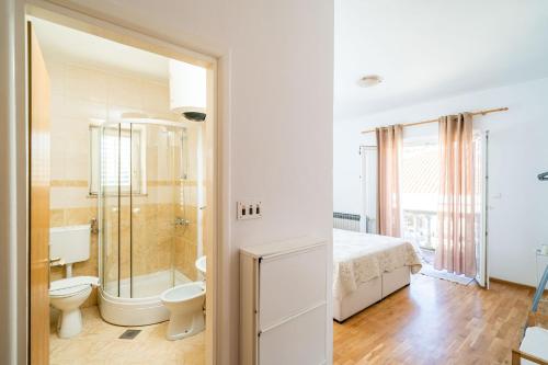 łazienka z łóżkiem, prysznicem i toaletą w obiekcie Francesca Guesthouse w mieście Mlini