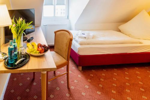 Pension Schlossblick في زوندرسهاوزن: غرفة مع سرير وطاولة مع وعاء من الفواكه