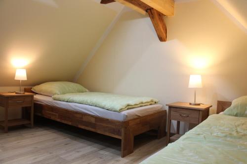 two twin beds in a room with two lamps at Ferienwohnung Windmühlenberg in Fürstlich Drehna