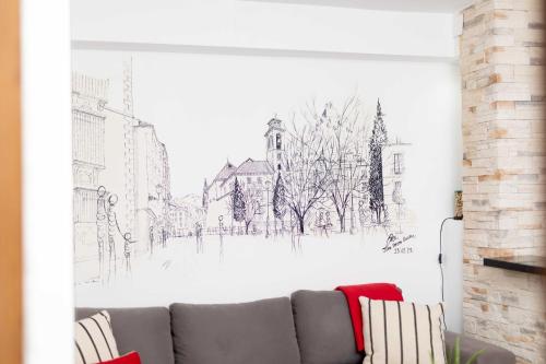 ein Sofa im Wohnzimmer mit Wandzeichnung in der Unterkunft ALBAICIN GLORIA DREAMS. A LOS PIES DE LA ALHAMBRA in Granada