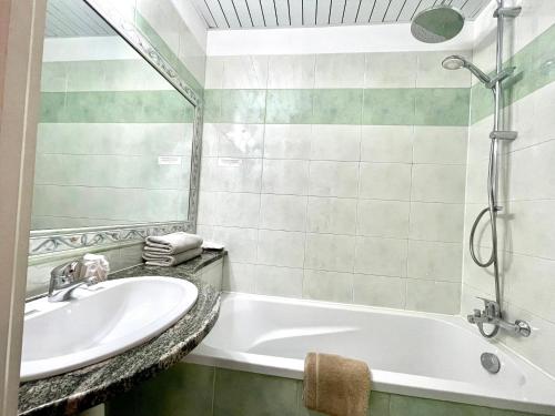 a bathroom with a sink and a bath tub at Le Mirval in La Brigue