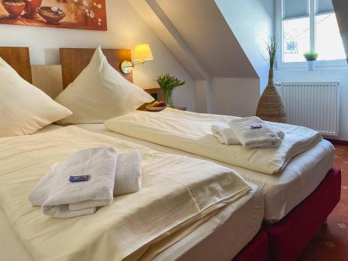 two beds in a room with towels on them at Pension Schlossblick in Sondershausen