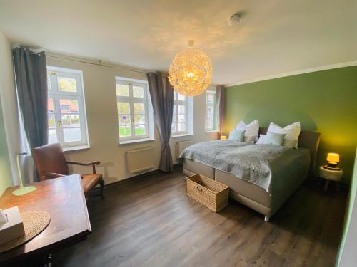 a bedroom with a bed and a table and a chandelier at Fewo Heinrichser Markt - 2 Schlafzimmer mit Sauna und Terrasse in Suhl