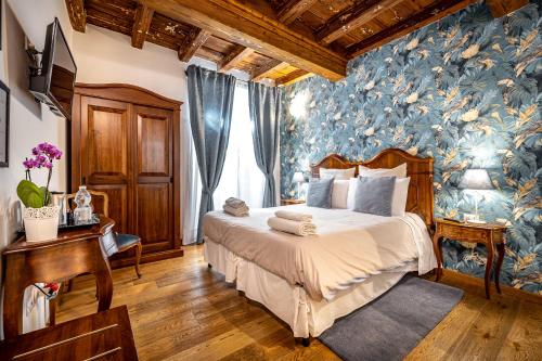 a bedroom with a large bed with a blue wallpaper at La Stella d'Oro B&B in Florence