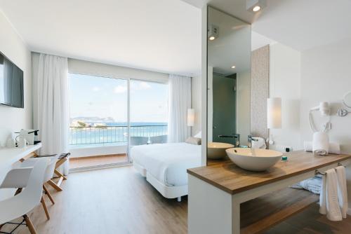 a bedroom with a bed and a large window at AluaSoul Ibiza - Adults only in Es Cana