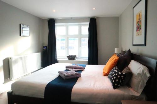 sypialnia z dużym łóżkiem z poduszkami w obiekcie 147 knapp road house w Londynie