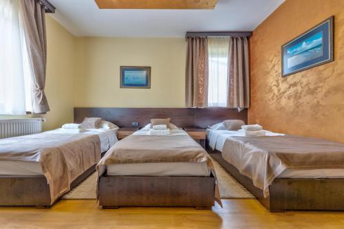 a bedroom with three beds in a room at Vila Monix Club Zlatibor in Zlatibor