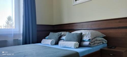 a bedroom with a bed with blue sheets and pillows at Pokoje Gościnne Nad Cukiernią w centrum miejscowości. in Jastarnia