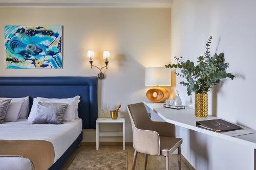 een slaapkamer met een blauw bed en een bureau met een laptop bij Golden Hotel in Marina di Cecina