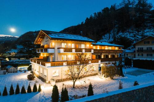 a house in the snow at night at Hotel Bischofhof in Chiusa