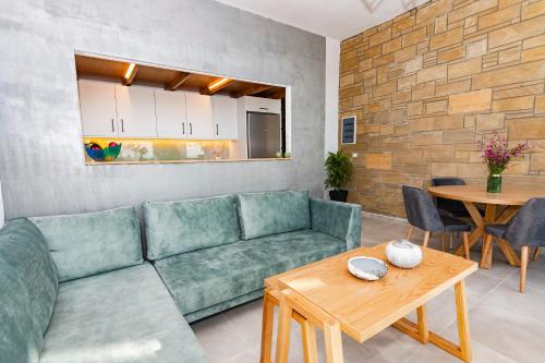 a living room with a green couch and a table at Rikanthos Stone Sea View Apartment Ι in Falelianá