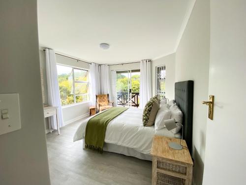 um quarto branco com uma cama e janelas em 34 Summerplace em Knysna