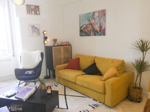 a living room with a yellow couch and a table at Maison du Bonheur l Art de vivre à la française Logement entier avec parking in Sainte-Savine