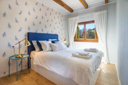 a bedroom with a large bed with blue butterflies on the wall at Casa Azul Stylish beach house for 4 adults and 1 child in Cala Llombards in Cala Llombards