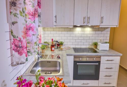 een keuken met witte kasten en een wastafel bij Vicky’s Luxury Apartment Sidari in Sidari