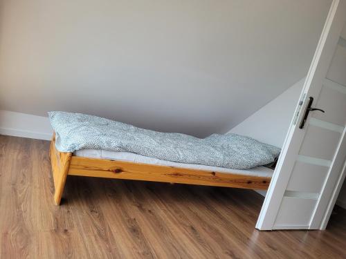 a bed sitting in a room next to a door at Apartamenty Drewniaki in Rydzewo