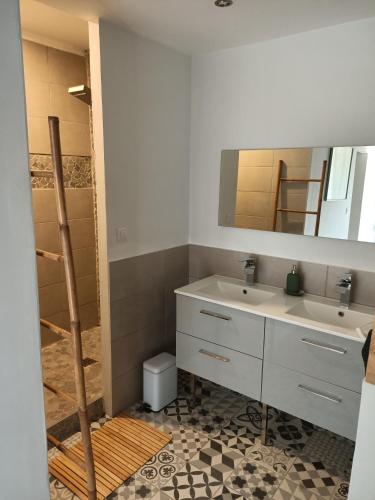 une salle de bain avec deux lavabos et un miroir dans l'établissement Maison de caractère au cœur de la cité médiévale de Gourdon, à Gourdon