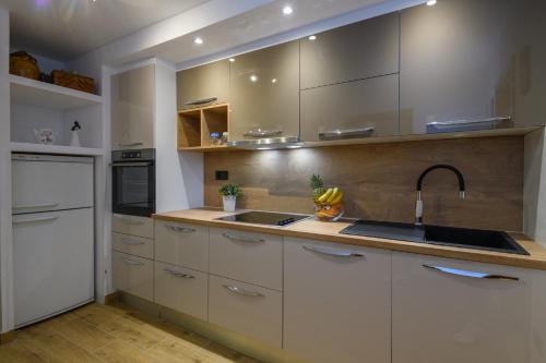 een keuken met witte kasten en een spoelbak bij Ivan Apartment in Dubrovnik