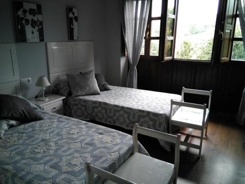 カンガス・デル・ナルセアにあるCasa Faruxoのベッドルーム1室(ベッド2台、テーブル、椅子付)
