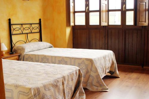 a bedroom with two beds and a window at Casa Faruxo in Cangas del Narcea