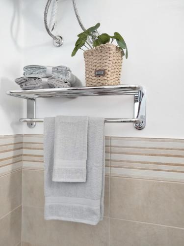 a towel rack in a bathroom with towels and a plant at Finestra sul Mare di Alessandro in Balestrate