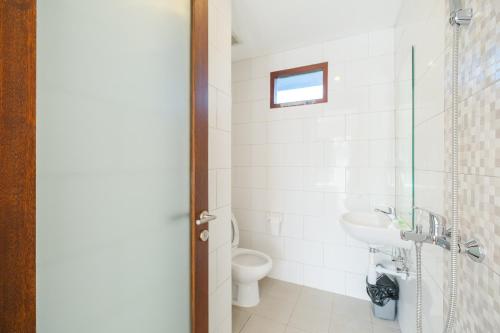 ein Bad mit einem WC und einem Waschbecken in der Unterkunft Dharma Guest House Seminyak RedPartner in Seminyak