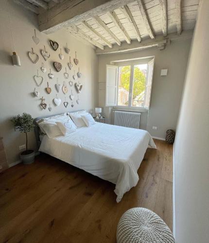 Un dormitorio con una gran cama blanca y una ventana en Alberto e Costanza Suite, en Lucca