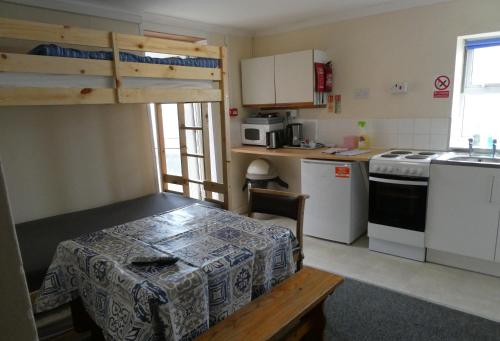 een kleine keuken met een tafel en een fornuis top oven bij Longbeach- Adults Only in Newquay
