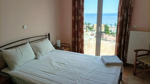 een slaapkamer met een bed met uitzicht op de oceaan bij Gythio Seaside Villa Dimitrios - Panoramic View in Gythio