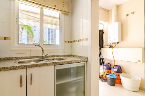 eine Küche mit einem Waschbecken und einem Fenster in der Unterkunft WintoWinRentals Great Terrace, 2º line beach & Pool in Rincón de la Victoria