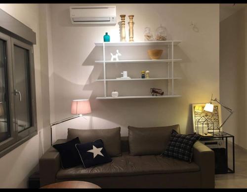 a living room with a couch and white shelves at Nikaia Metro House in Piraeus