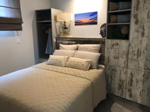 uma cama com lençóis brancos e almofadas num quarto em LE JARDIN D EDEN em Frontignan