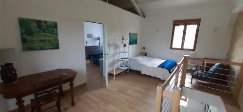 a room with a bedroom with a bed and a desk at LA CHOUETTE in Neuville-Bosc