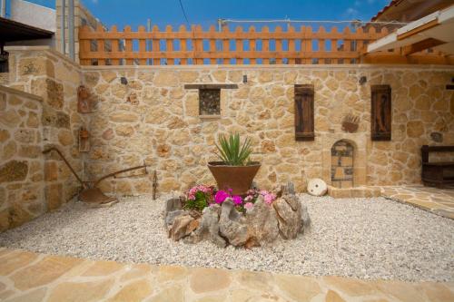 a stone building with a potted plant in a courtyard at Pamelas House with Jacuzzi in Kissamos