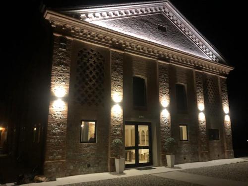 a large brick building with lights on it at night at Agriturismo Il Capitolo in Carpaneto Piacentino