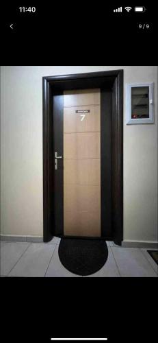 una puerta marrón con una alfombra negra delante de ella en Superior studio, en Heraclión