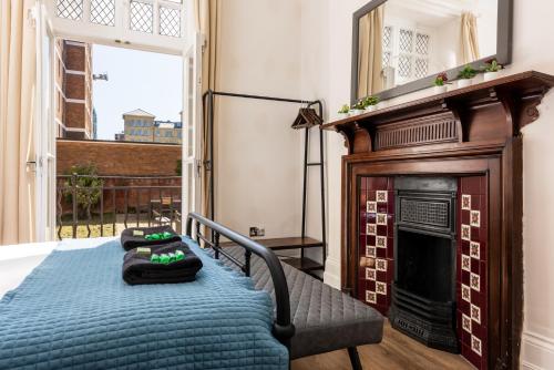 a bedroom with a fireplace and a bed with two pillows at 3 Bedroom Garden Apartment Opposite the Beach in Brighton & Hove