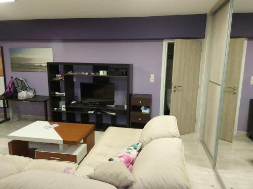 a living room with a white couch and a tv at Arman Group Basement Loft in Athens