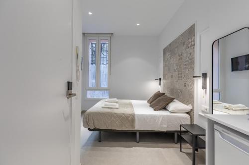 Habitación blanca con cama y espejo en Comfortable Room close to City Centre, en Valencia