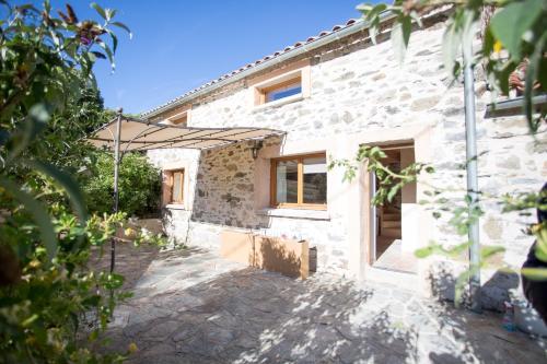 a stone house with a view of the courtyard at Gîtes du Pont de Calmel in Rieussec