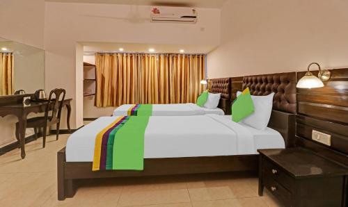 a bedroom with a large bed and a desk at Treebo White Inn Koramangala in Bengaluru