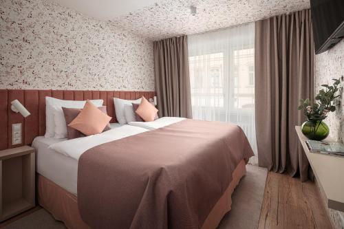 um quarto de hotel com uma cama grande e almofadas cor-de-rosa em Dlouha Apartments Old Town Prague em Praga