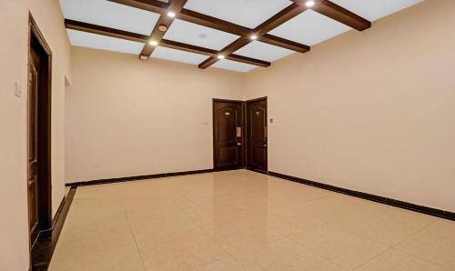 an empty room with wooden doors and a ceiling at Treebo White Inn Koramangala in Bengaluru