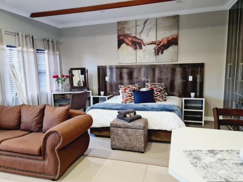 a bedroom with a bed and a couch at The Hank Bethlehem Pty Ltd in Bethlehem