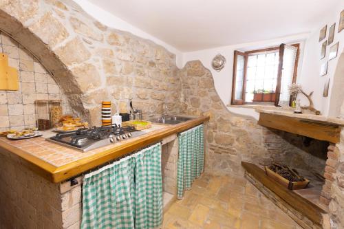 een keuken met een wastafel en een stenen muur bij Porta della Valle Casa Vacanze in Castro dei Volsci