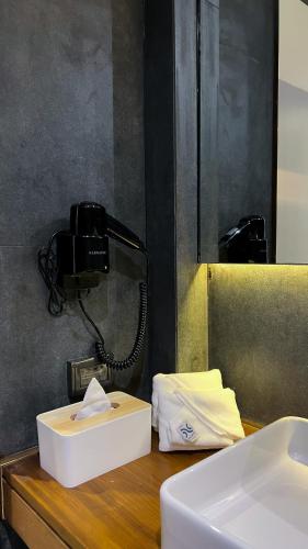 a phone sitting on a counter next to a sink at The Nhorm Hotel Ratchada in Bangkok