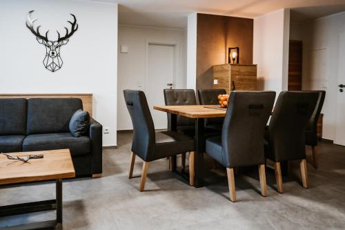 a dining room with a table and chairs and a couch at My Lodge Winterberg in Winterberg