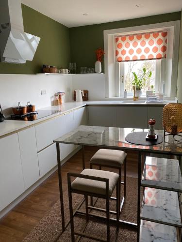 a kitchen with a glass table and chairs in it at Arbroath luxury apartment in MCM style in Arbroath