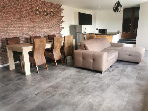 un salon avec un canapé, une table et des chaises dans l'établissement Gites les Gambes, à Échenoz-le-Sec