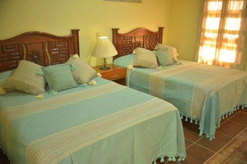 a bedroom with two beds and a lamp at OYO Hotel Castillo Santa Cecilia in Tapalpa
